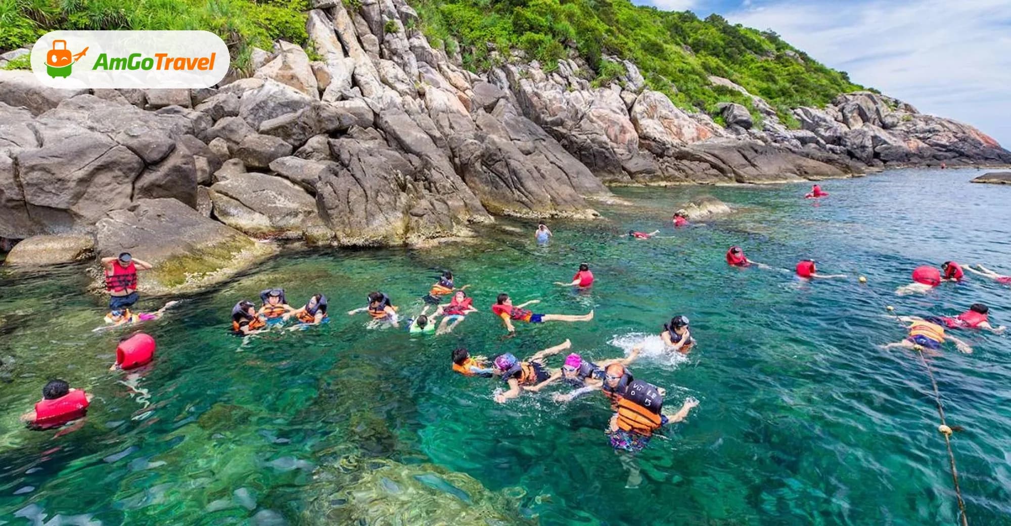 Snorkellers in clear turquoise water by rocky island shore