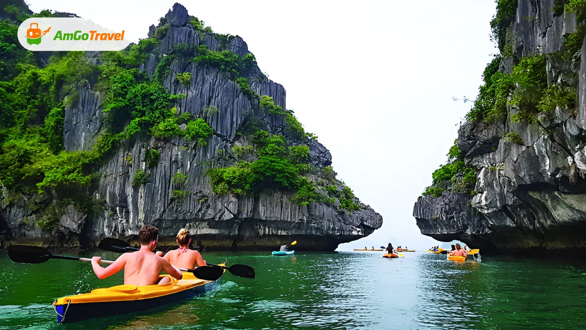 Couple kayaking between limestone cliffs on green water