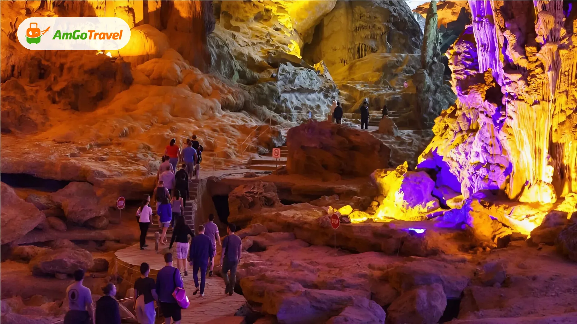 Visitors inside illuminated limestone cave in Ha Long